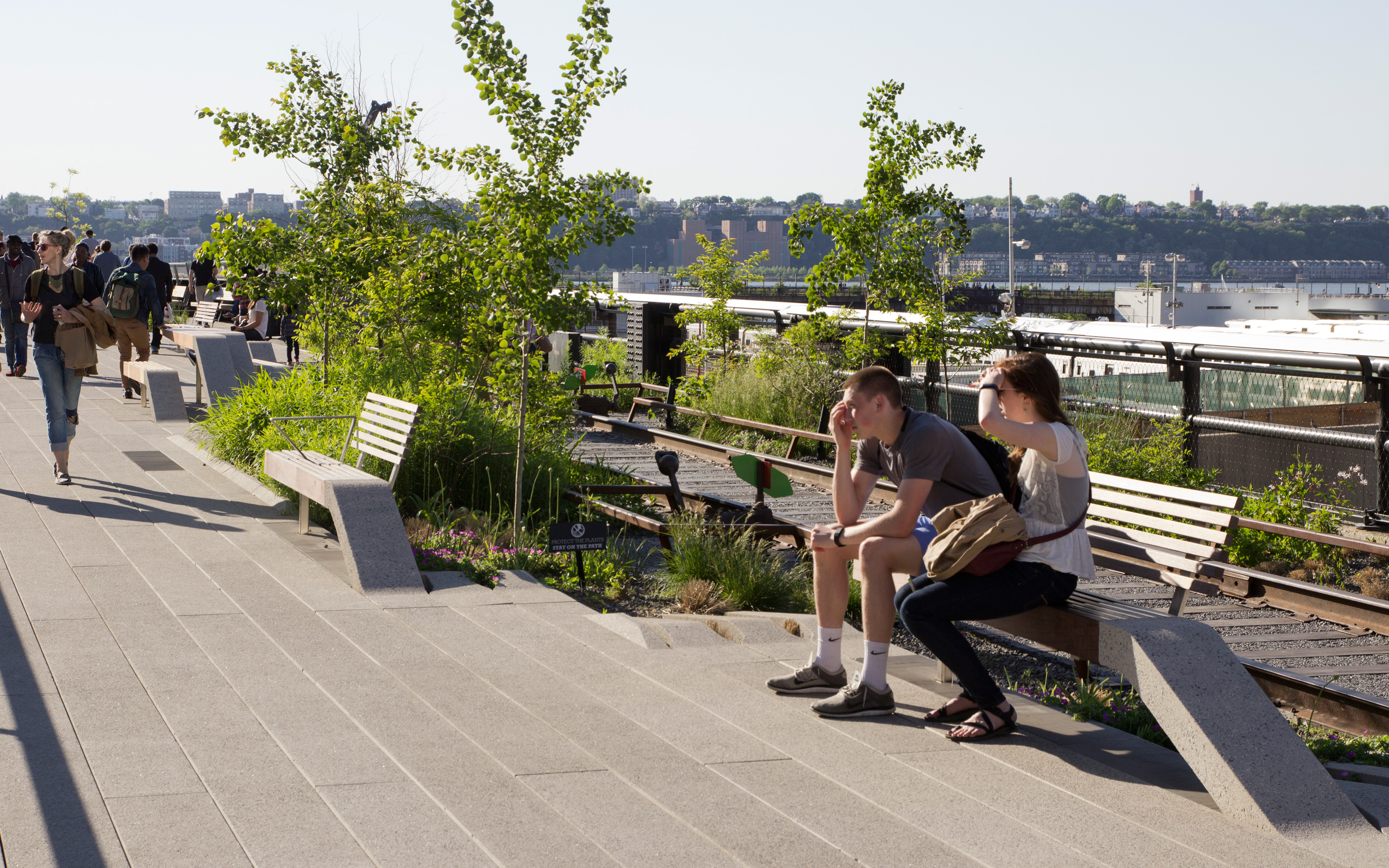 Zwei Personen sitzen auf einer Bank auf einem Dachgarten