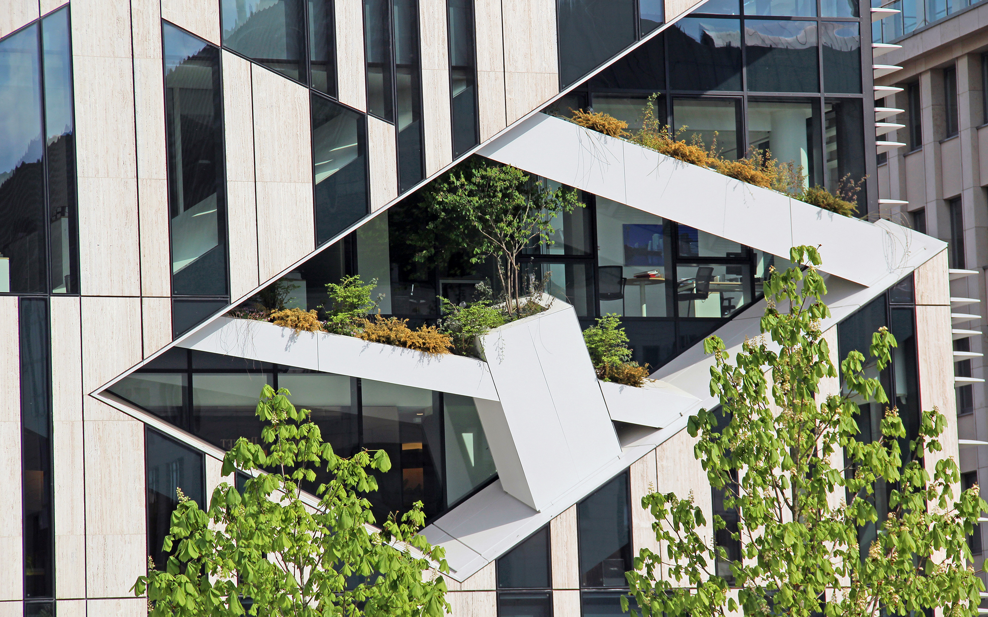 Einzelne Partien in der Fassade sind diagonal eingeschnitten und bepflanzt.