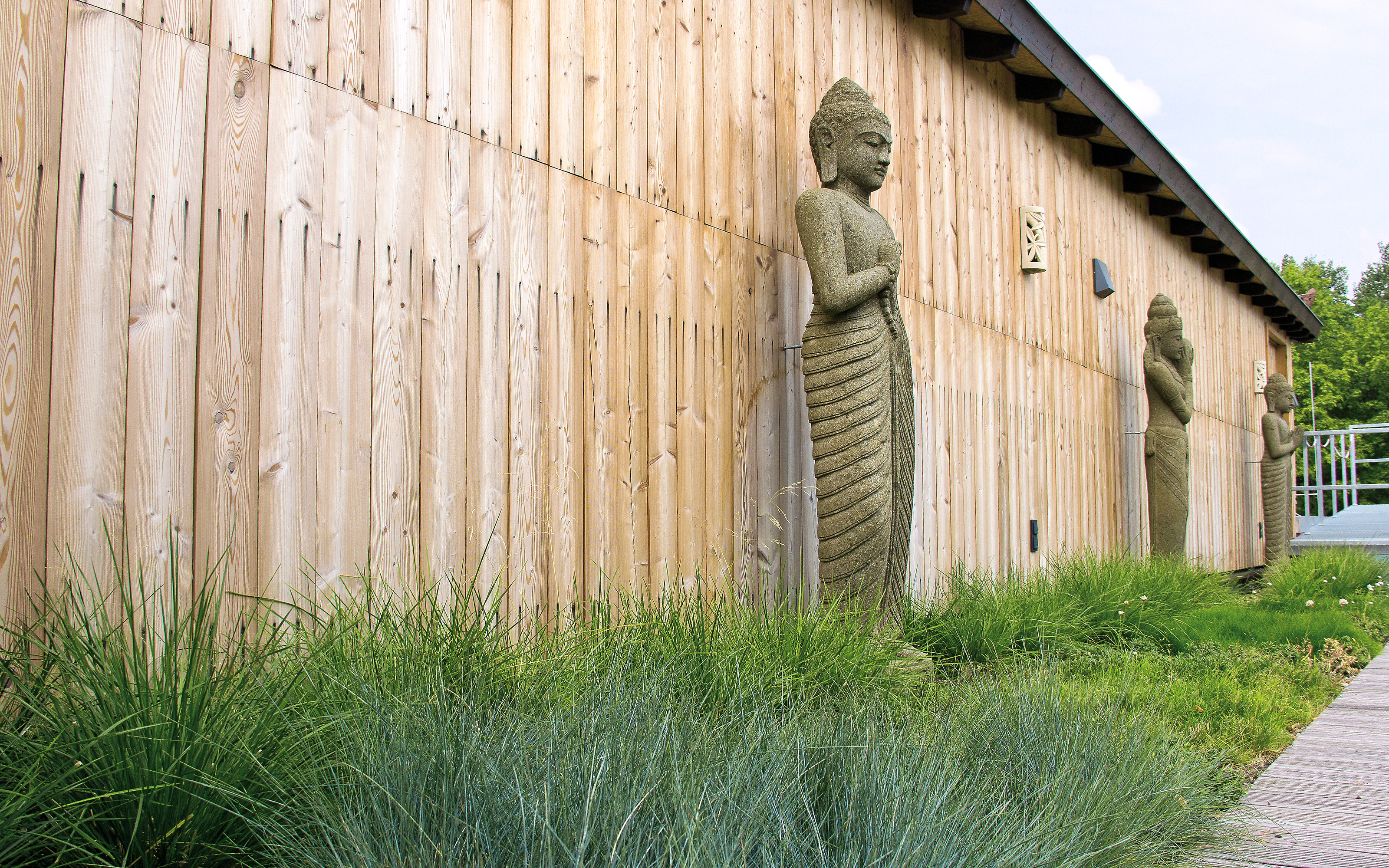 Buddha-Figuren vor einer Holzwand