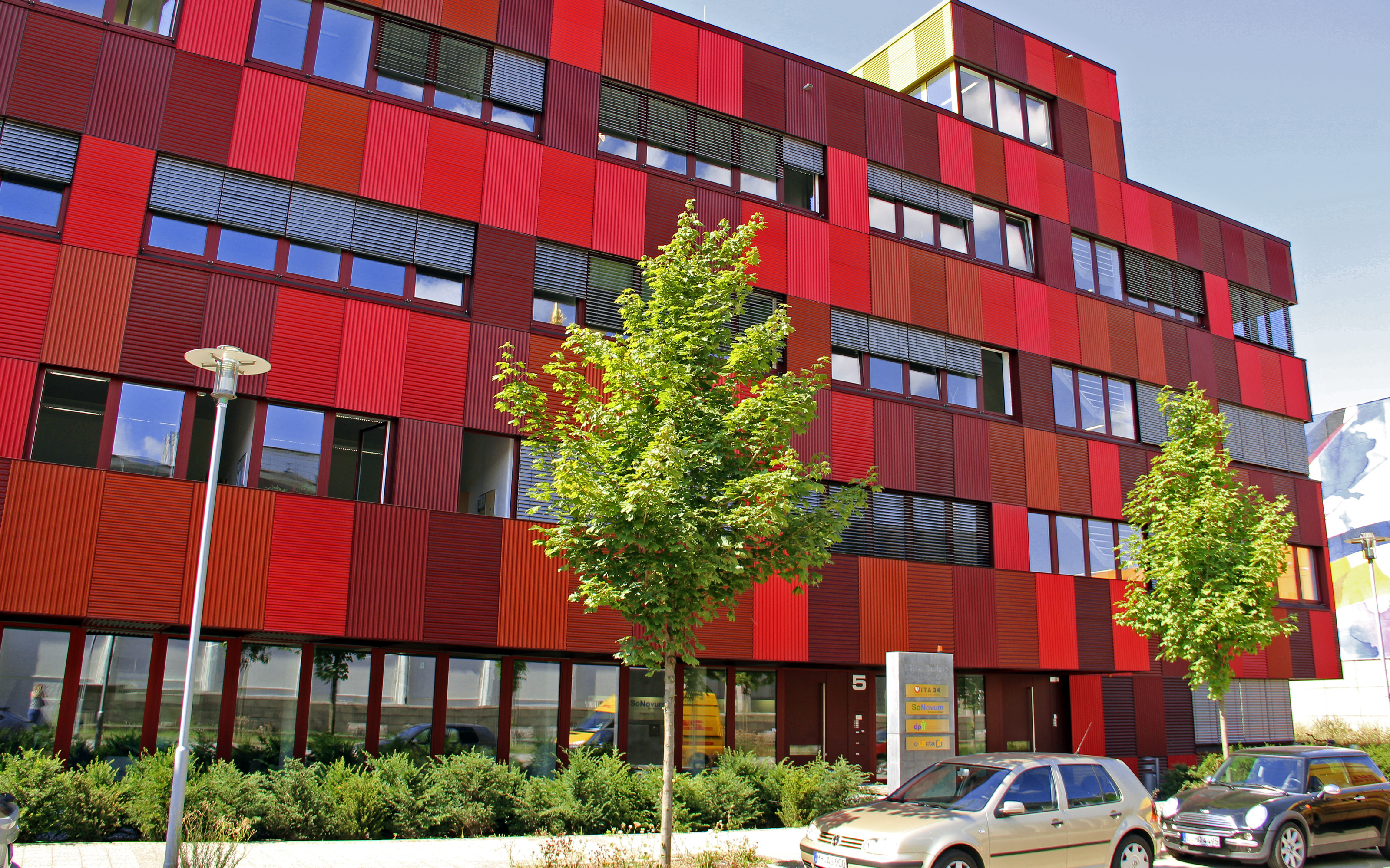 Gebäude mit roter Fassade und kleine Bäume