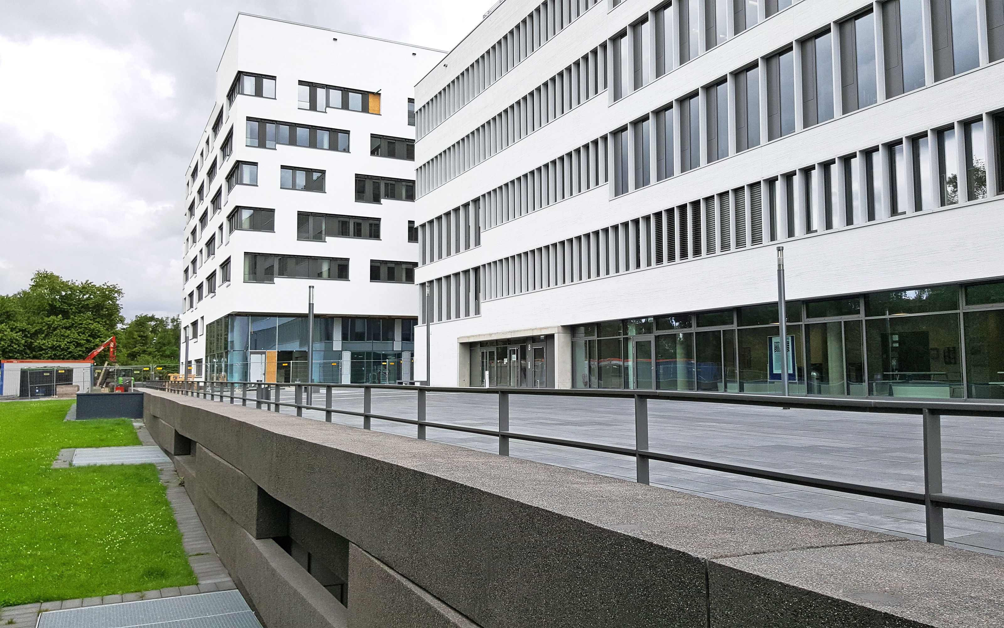 Gebäude mit weißer Fassade mit Gehbelagsflächen auf einer Tiefgarage