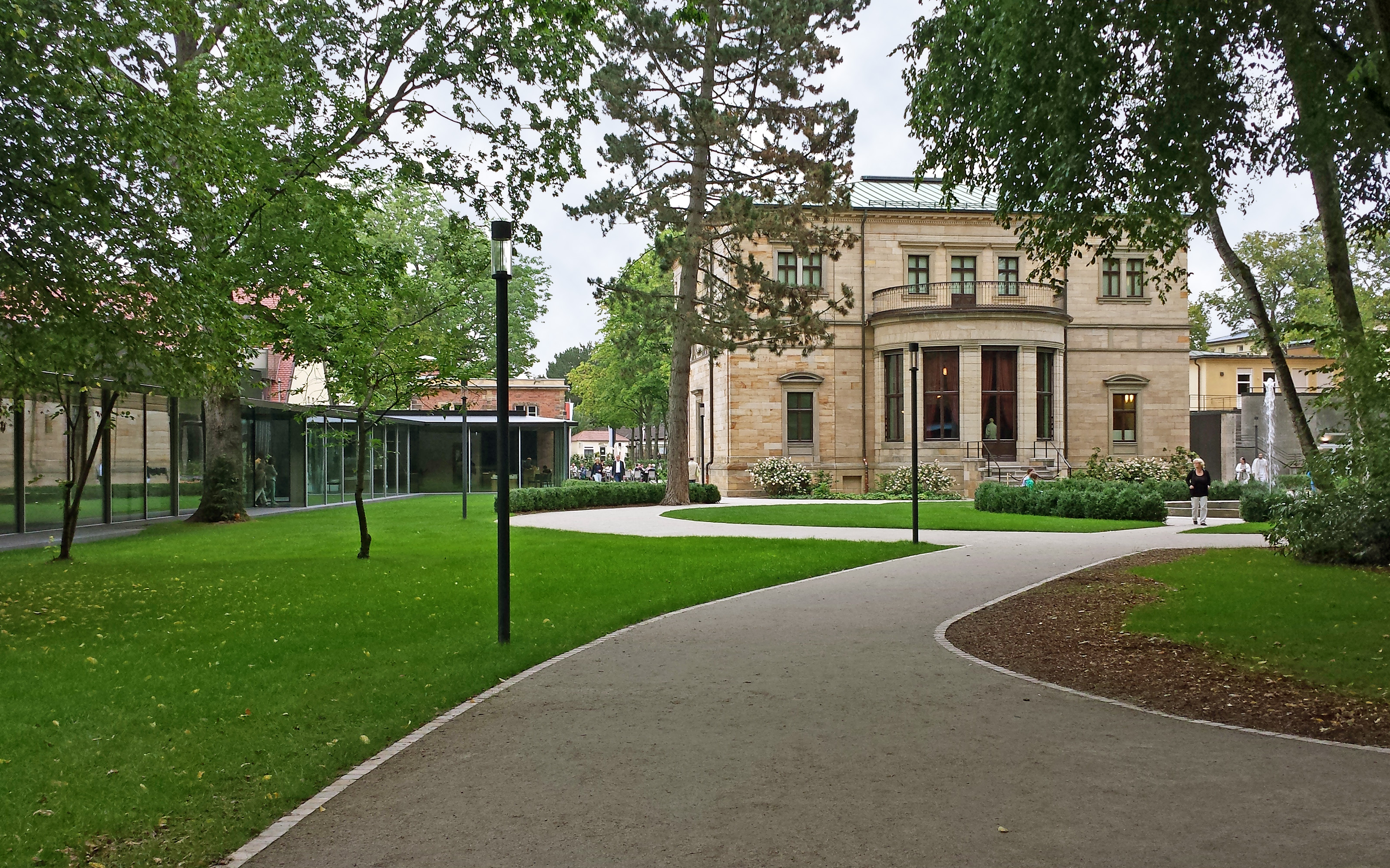 Parkanlage mit Glasbau und historischem Gebäude