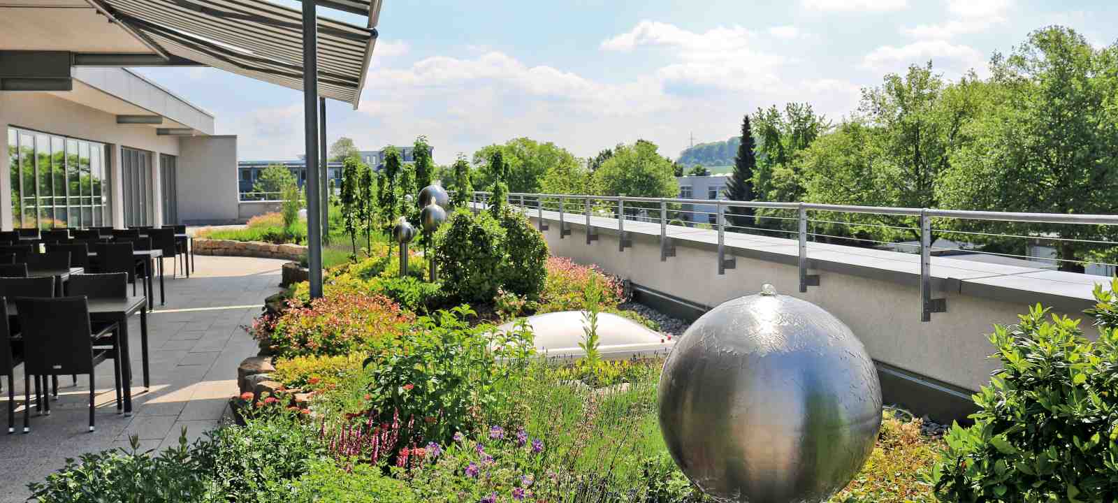 Dachgarten mit Staudenpflanzung, Wasserspielen und Terrassenfläche mit Sitzgelegenheiten