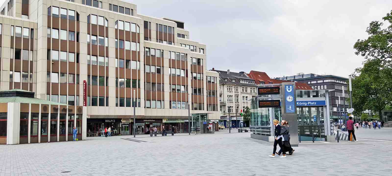 Menschen auf einem Platz in der Stadt, umgeben von Häusern