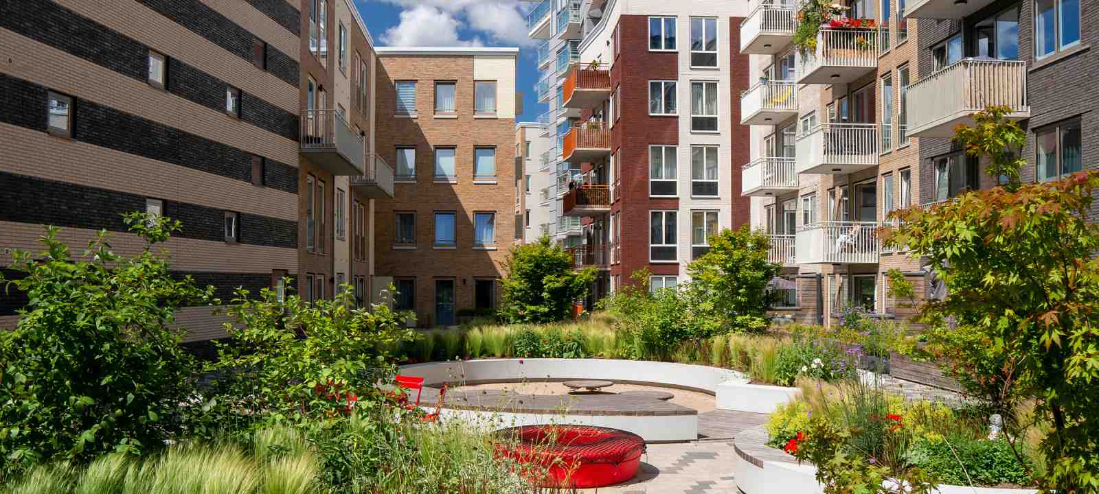 Begrünter Innenhof mit Spielplatz in einem Wohnkomplex