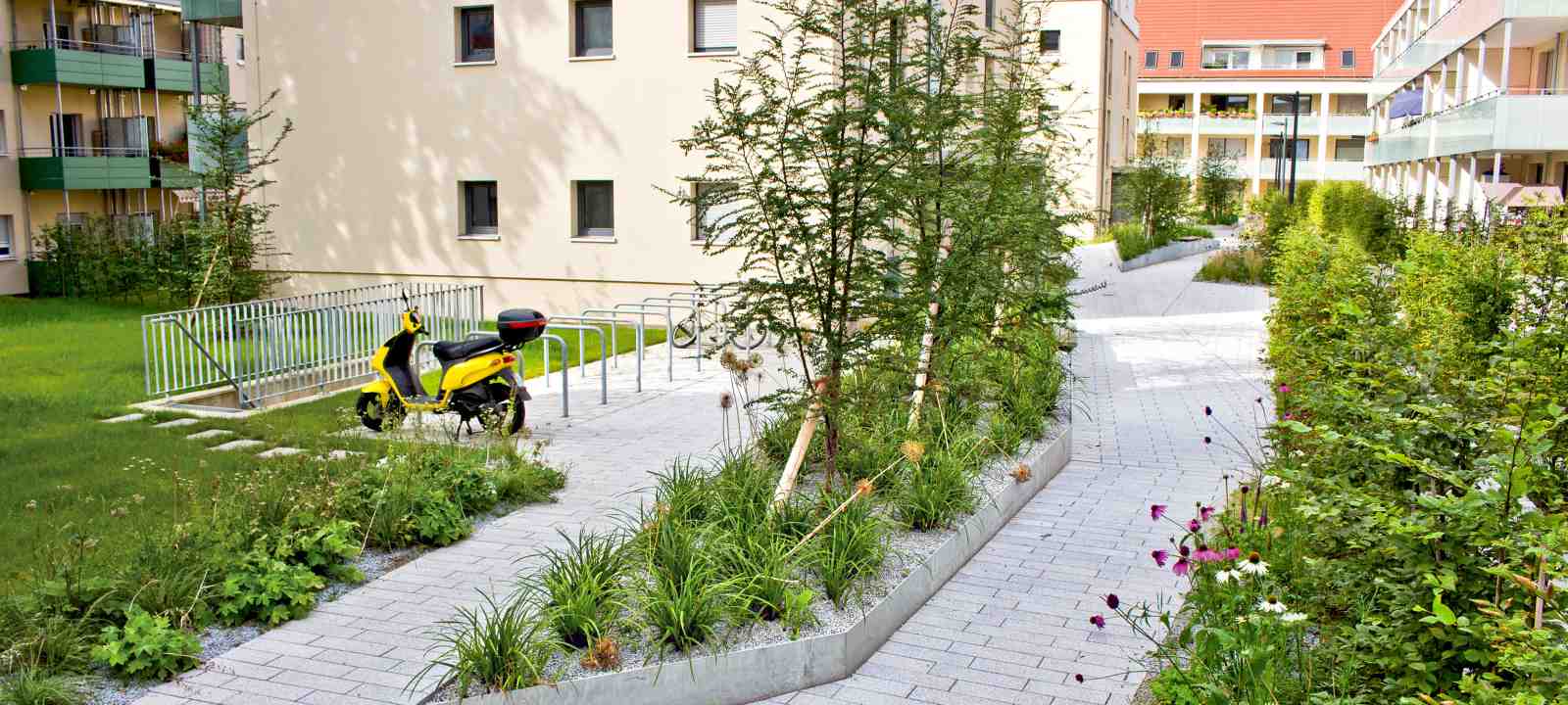 Motorroller in einer begrünten Wohnanlage