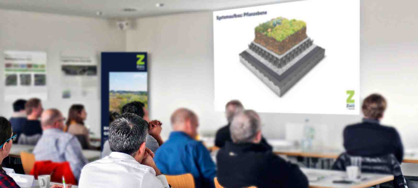 Personen in einem Gründach-Seminar
