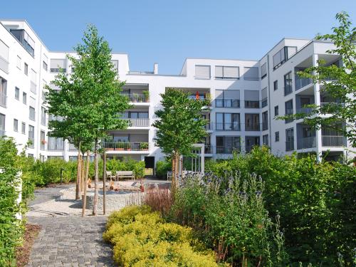 Üppig bepflanzter Garten mit Spielplatz in einer Wohnanlage