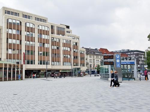 Menschen auf einem Platz in der Stadt, umgeben von Häusern