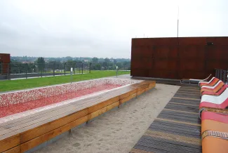 Sitzplätze neben einem Sandbereich auf dem Dach