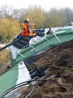 Eine Arbeitsbühne befördert das Material für den Systemaufbau auf das Dach