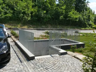 Für die Fahrbelagsflächen verwendete man aus ökologischen Gründen gebrauchtes Natursteinpflaster. Geh- und Fahrbeläge mit Natursteinpflaster und Treppendurchgang zur Tiefgarage