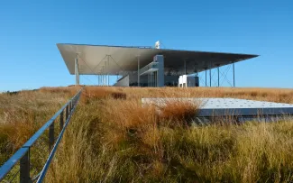 Flachdach-Gebäude, umgeben von herbstlichen Gräsern.