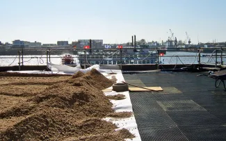 Substratschüttung auf einem Dach und Boot im Hintergrund