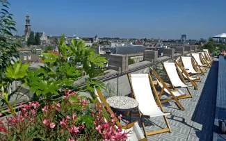 Dachterrasse mit Liegestühlen mit Blick auf die Stadt