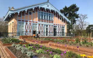 Historisches Gebäude mit Pflanzbeeten auf einer Terrasse mit Holzbelag