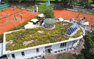 Begrüntes Dach mit Solar und Tennisplätze im Hintergrund