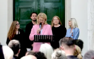 Frau Sabine Poschmann, MdB und Parlamentarische Staatssekretärin im Bundesministerium für Wohnen, Stadtentwicklung und Bauwesen, weist in ihrer Eröffnungsrede auf die Notwendigkeit klimaangepasster Stadtplanung hin. Im Hintergrund das Kuratorenteam mit Gabriele G. Kiefer, Daniele Santucci, Elisabeth Endres, und Nicola Borgmann (v. Li). Sprecherin hält eine Rede