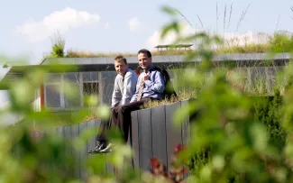 Zwei Personen sitzen auf einem Gründach
