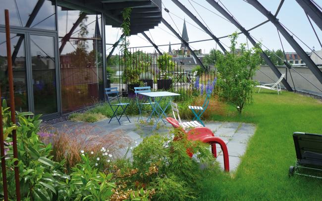 Dachgarten mit Terrassenfläche unter Stahlkuppel 