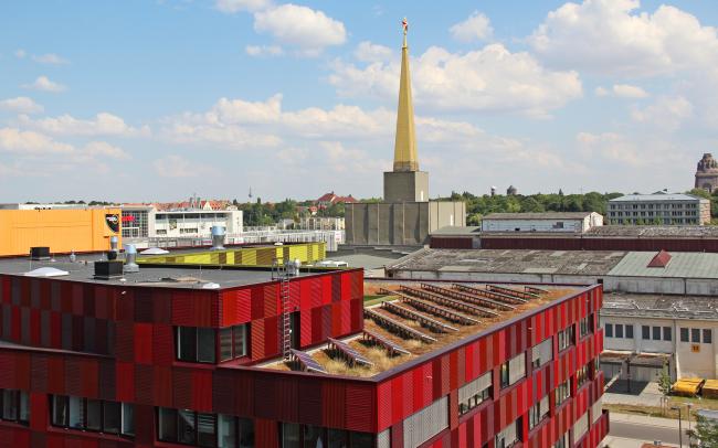 Gebäude mit roter Fassade und Photovoltaik auf dem Dach