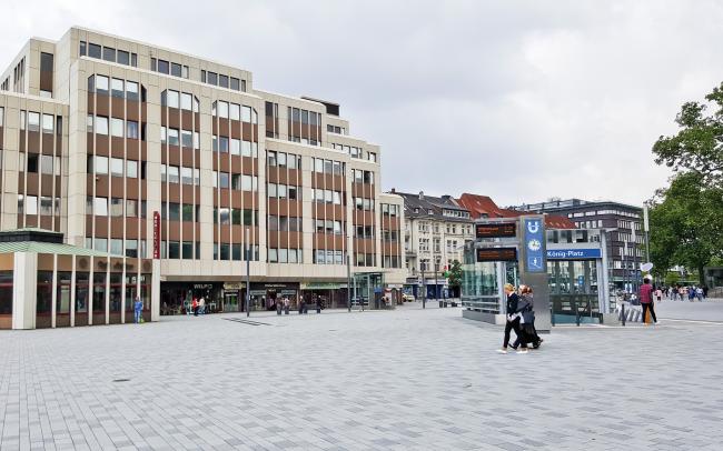 Menschen auf einem Platz in der Stadt, umgeben von Häusern